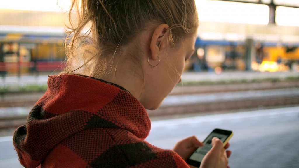 Adolescente que usa datos en un iPhone